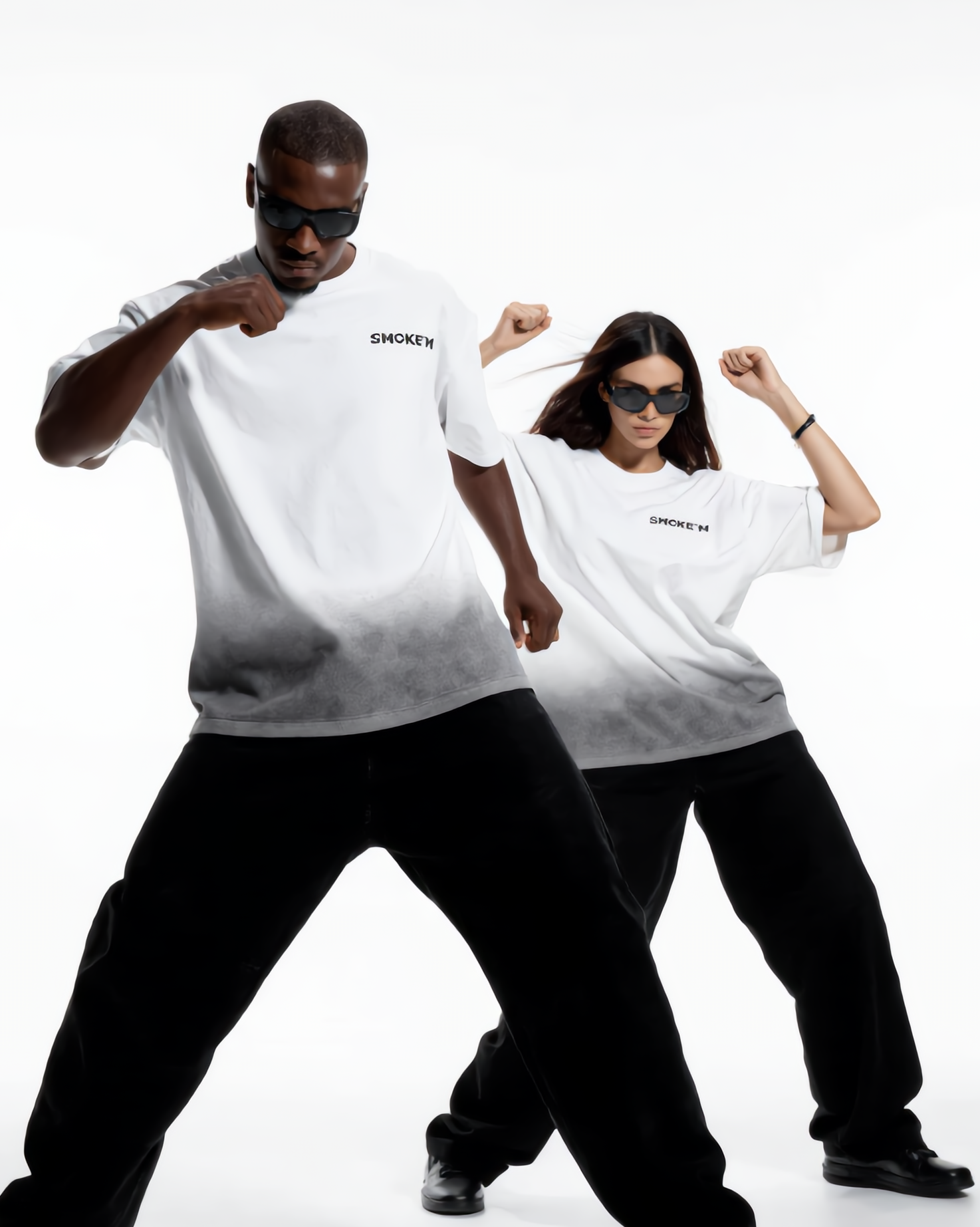 Two people wearing matching white t-shirts and black pants on a white background