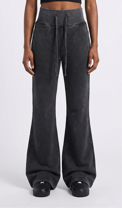 Person wearing dark black high-waisted pants on a white background