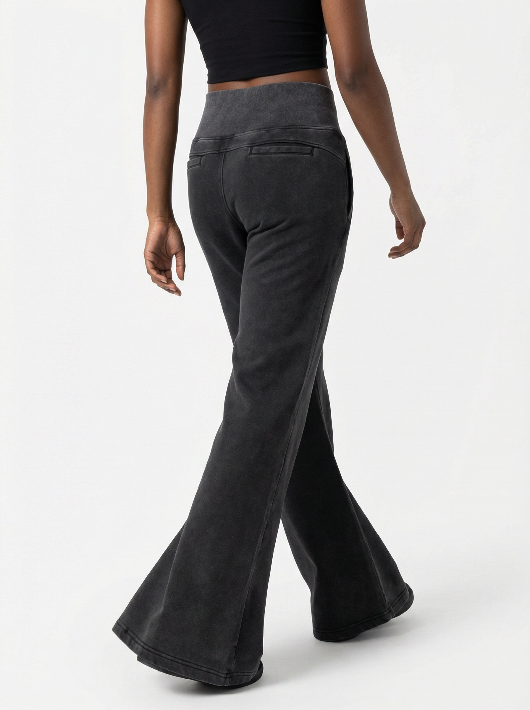 Black flared pants worn by a person on a white background