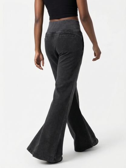 Black flared pants worn by a person on a white background